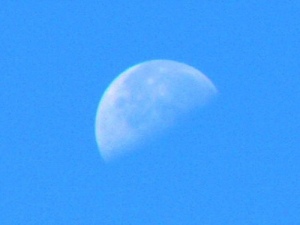 Upturned waning half moon in the daytime sky.